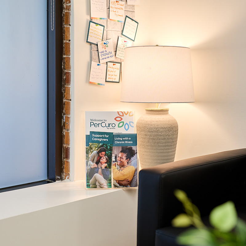 Coin chaleureux d’une clinique PerCuro avec une brochure d’accueil